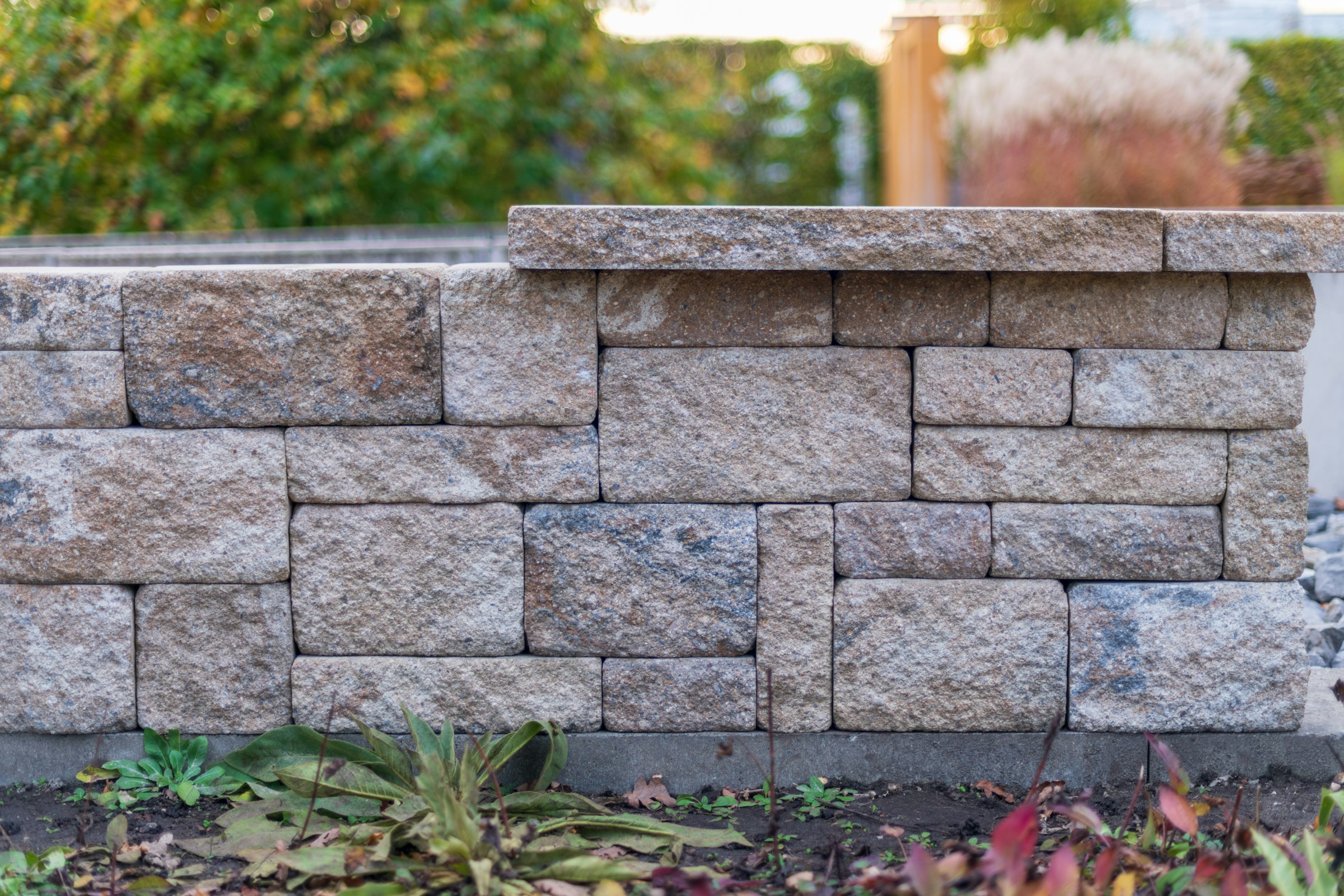 Dry-stacked stone garden wall above a planting bed